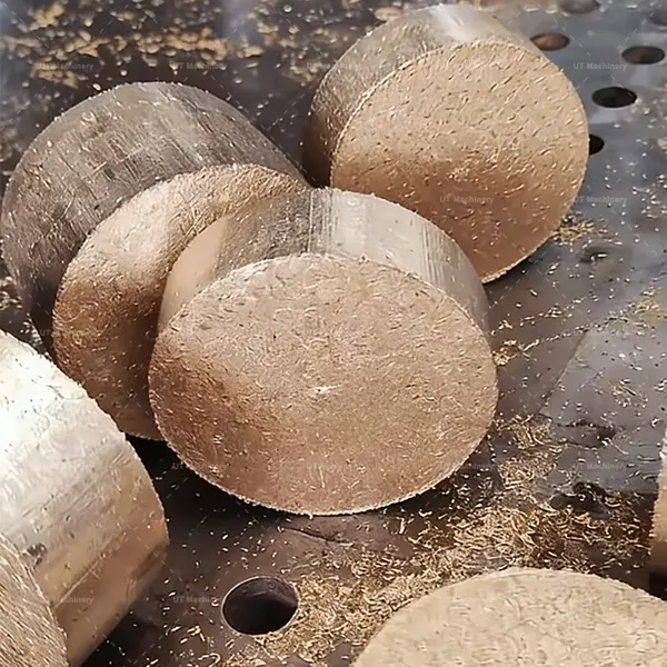 A stack of dense, circular copper briquettes compressed from swarf, ready for melting.