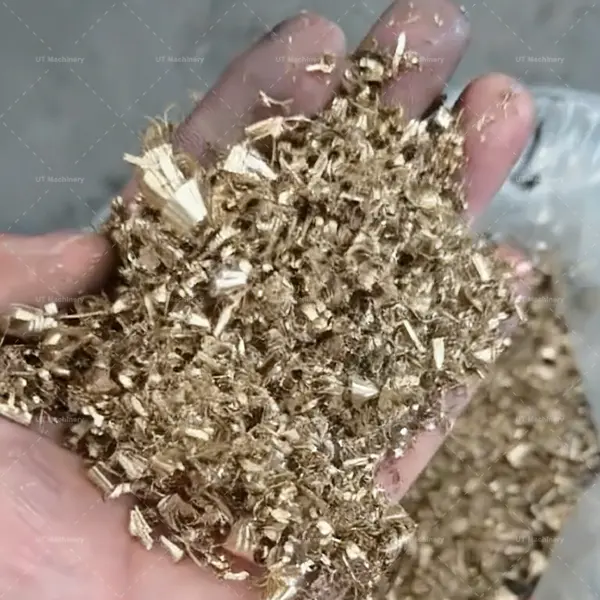 Close-up of messy, loose copper swarf soaked in cutting oil from a machining workshop.
