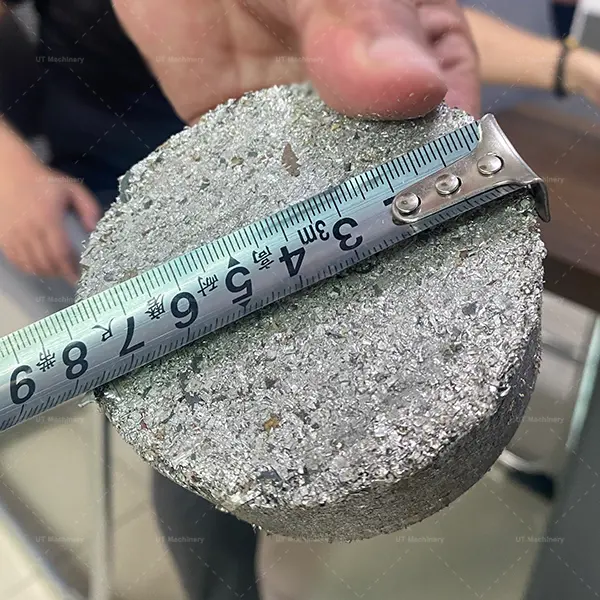 Measuring the diameter of a finished aluminum briquette to verify density