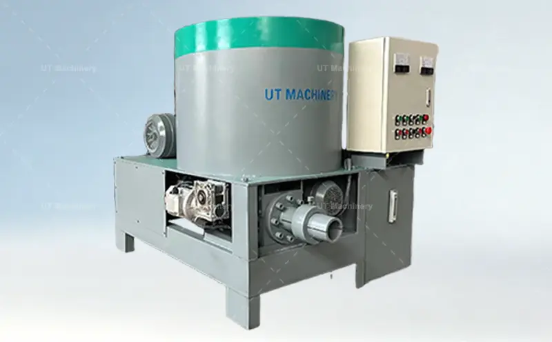 A detailed side view of the UT MACHINERY brand rice husk briquette press, showcasing the electric motor, exposed gearbox drive system, and the heavy-duty metal frame structure.