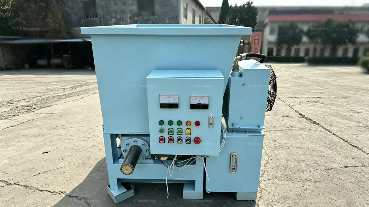 Front view of UT Machinery hydraulic biomass briquette press machine with 60mm outlet and control panel.