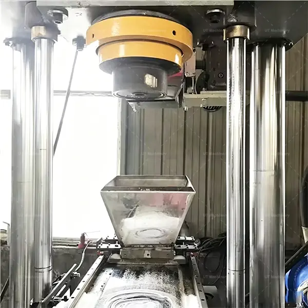 Stainless steel gravity feeding hopper and heavy-duty compression cylinder chamber of a vertical metal briquetting press.