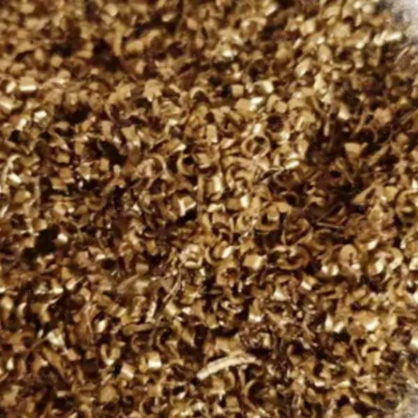 Curly brass turnings and metal scrap shavings generated from CNC lathe machine processing.