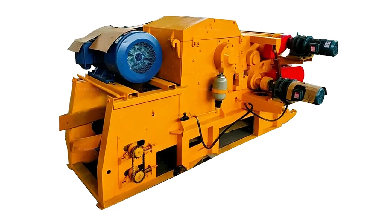 A detailed close-up shot focusing on the central chipping mechanism of a yellow industrial drum chipper, highlighting the main blue drive motor, the large belt-driven pulley system with its red guard, and the intricate hydraulic tensioning components.